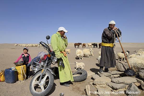 Mongolia. Bakankhongor province. Gobi desert, Sinejinst village. Two cashmere breeders and a child at a waterpoint.